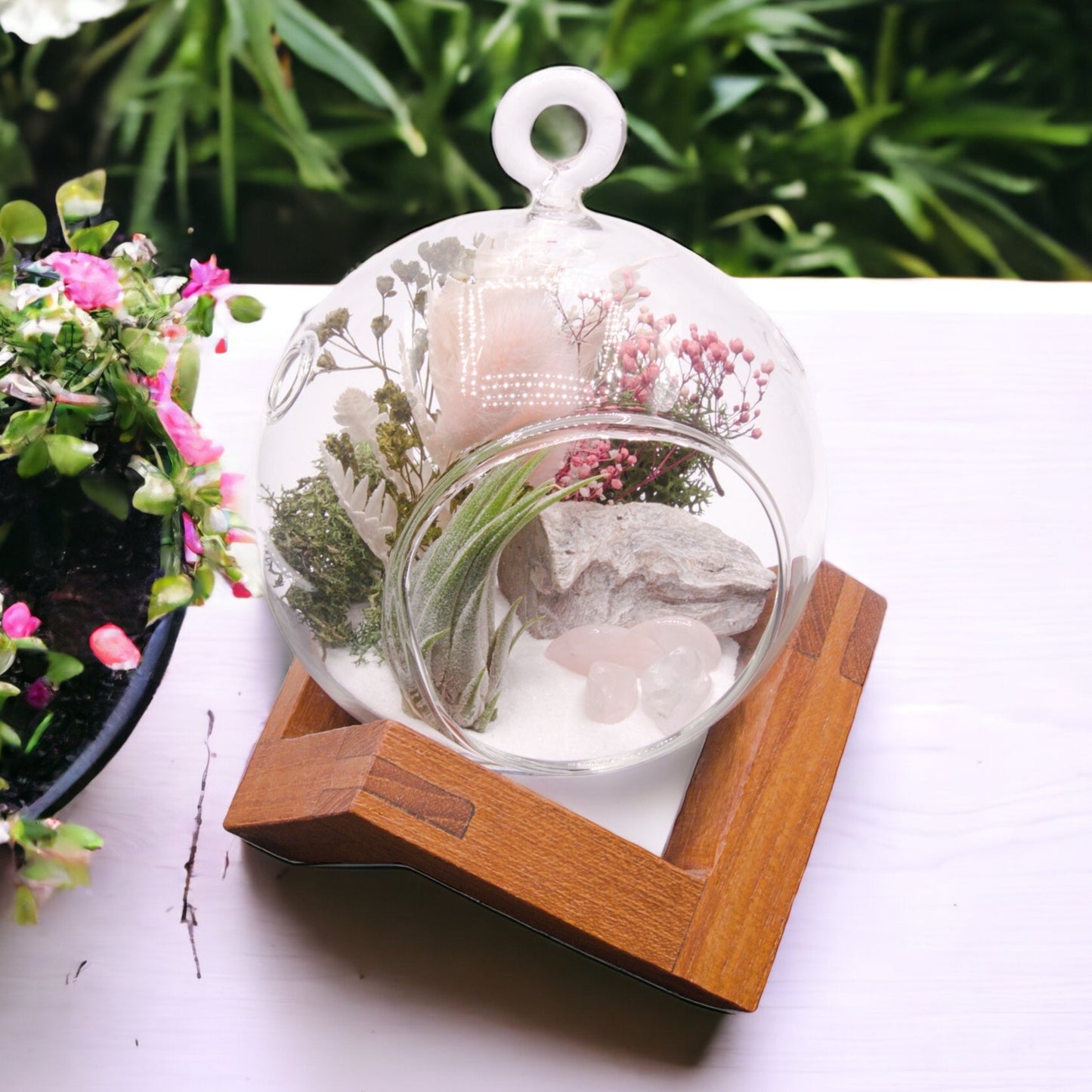 Glass bubble airplant terrarium with dried flowers and rose quartz crystals
