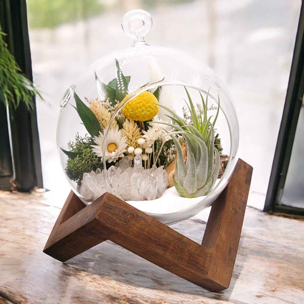 Glass bubble airplant terrarium with sand, dried flower bouquet, crystal quartz cluster