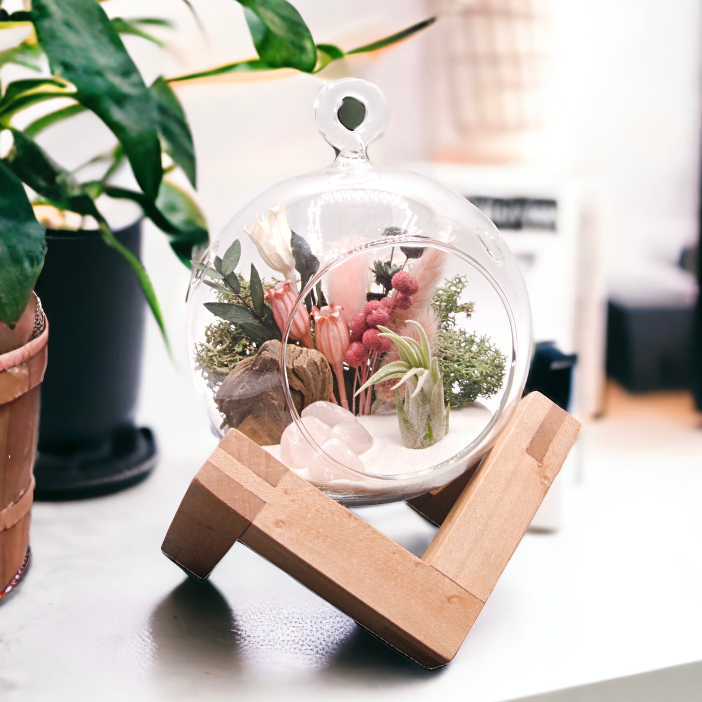 Glass bubble airplant terrarium with dried flowers and rose quartz crystals