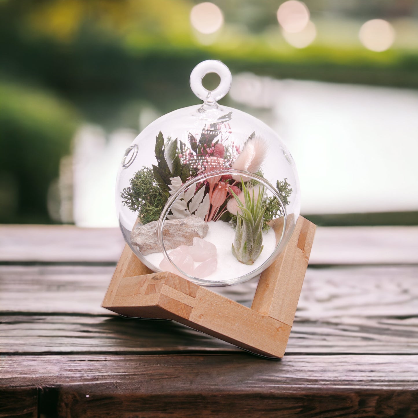 Glass bubble terrarium with airplant, dried flowers and rose quartz crystals