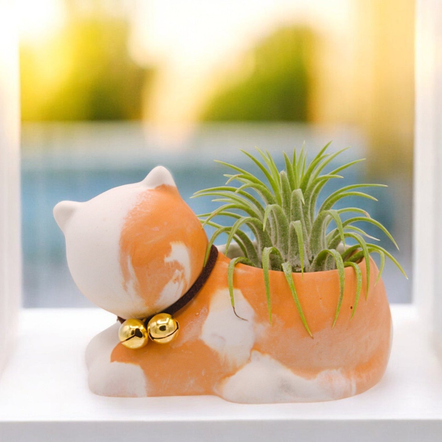 Handmade hydrostone pot in the shape of a cat with a faux-leather collar and bells