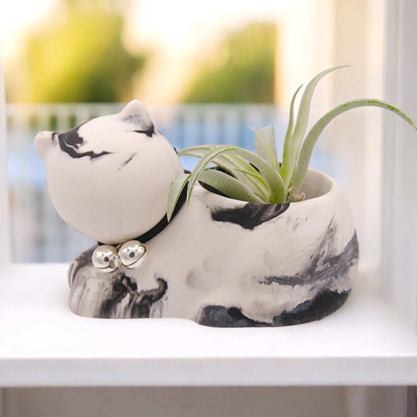 Handmade hydrostone pot in the shape of a cat with a faux-leather collar and bells