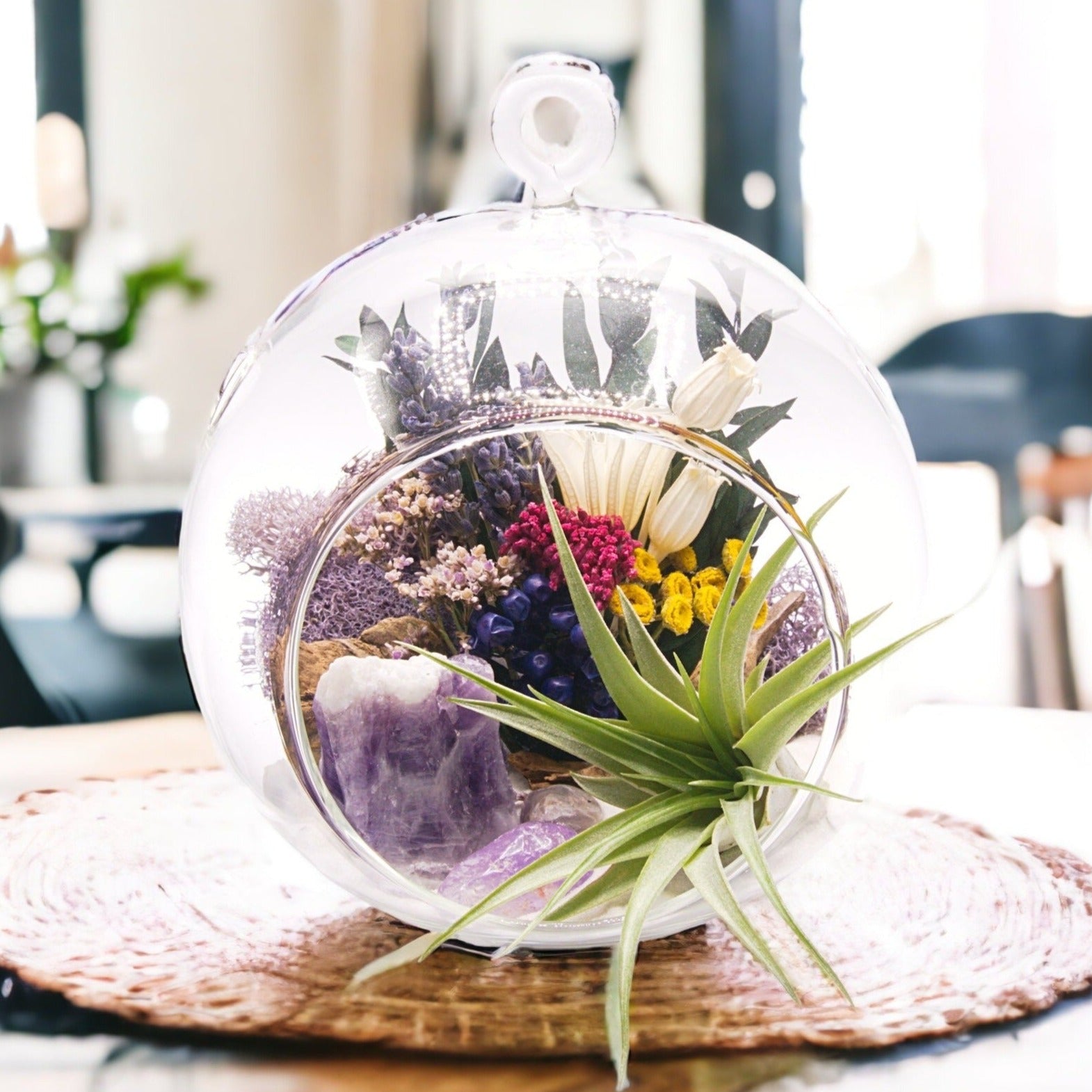 Glass bubble airplant terrarium with dried flowers and amethyst crystals