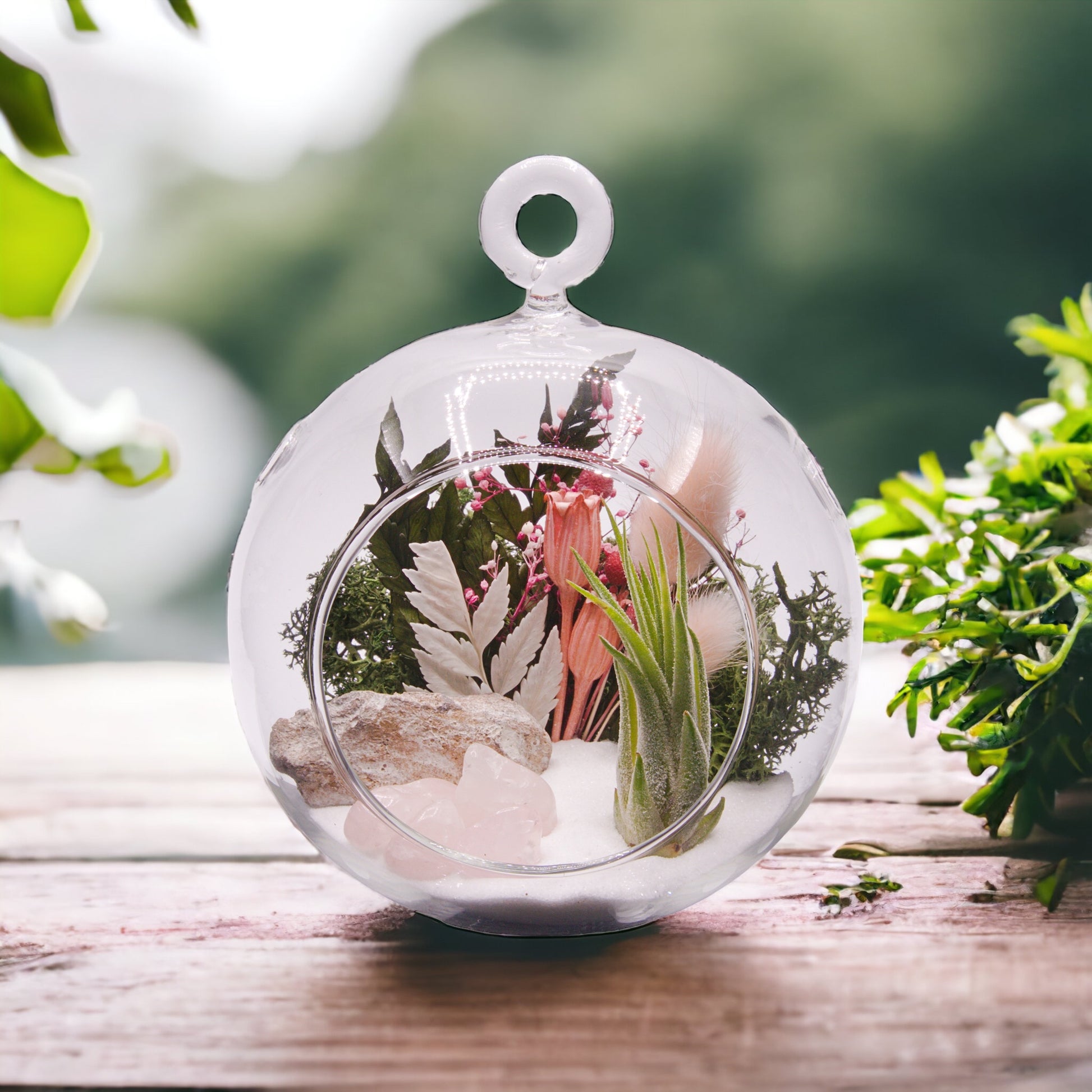 Glass bubble terrarium with airplant, dried flowers and rose quartz crystals