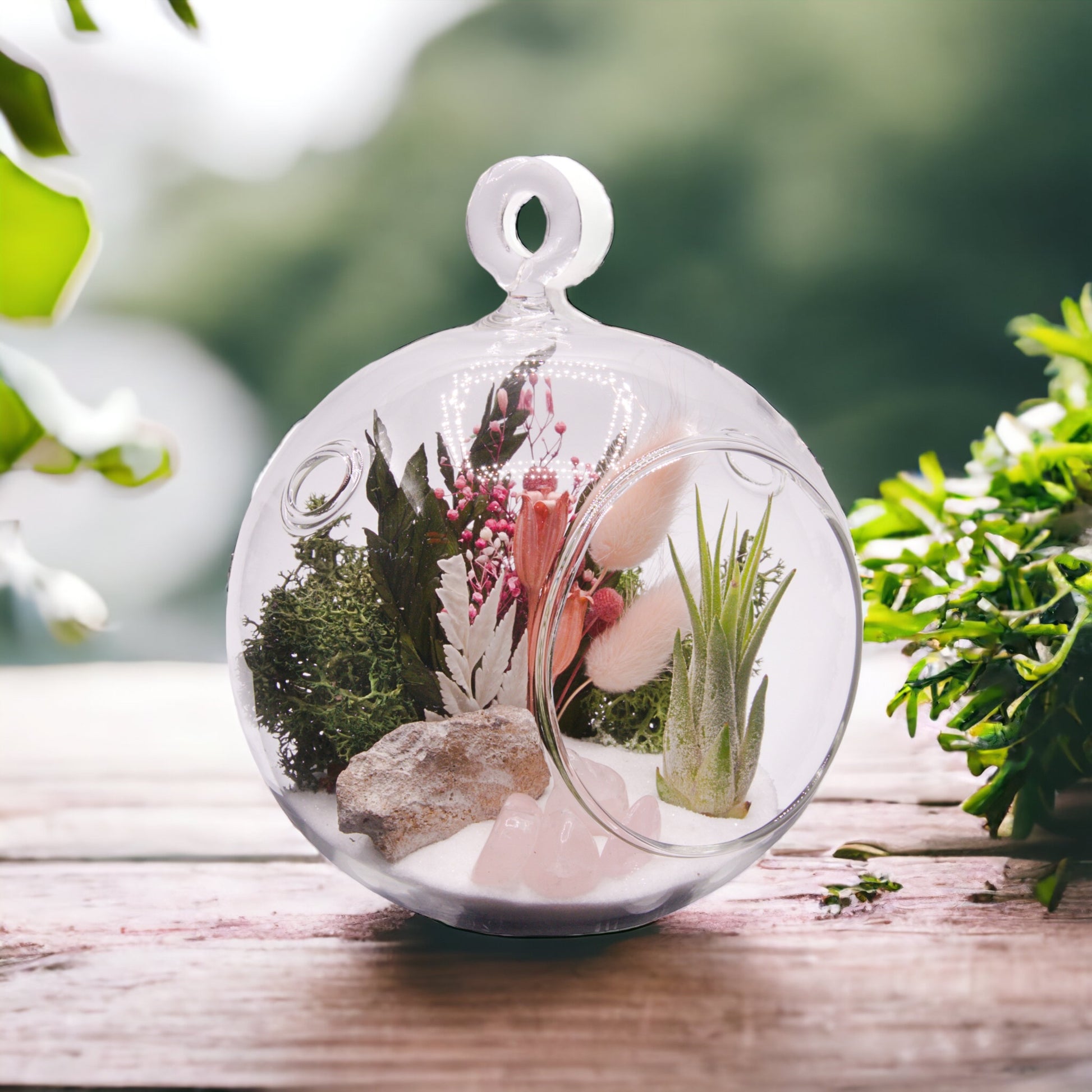 Glass bubble terrarium with airplant, dried flowers and rose quartz crystals