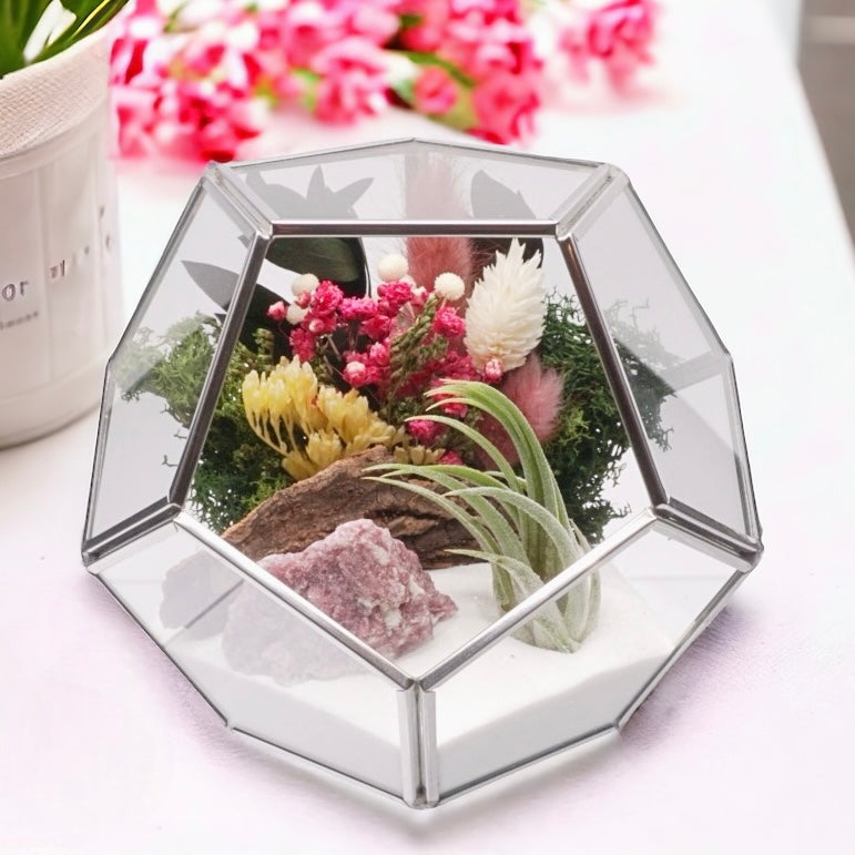 Airplant terrarium in a silver rimmed geometric glass vase with pink bouquet of dried flowers, moss, wood and pink tourmaline crystals