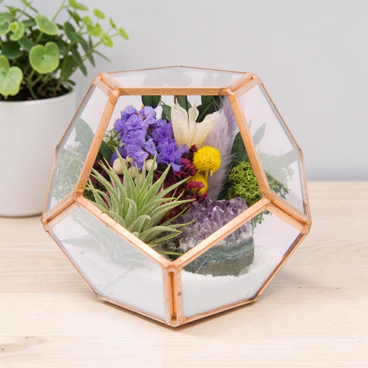 rose gold victorian style terrarium with dried flowers, an amethyst crystal and an airplant