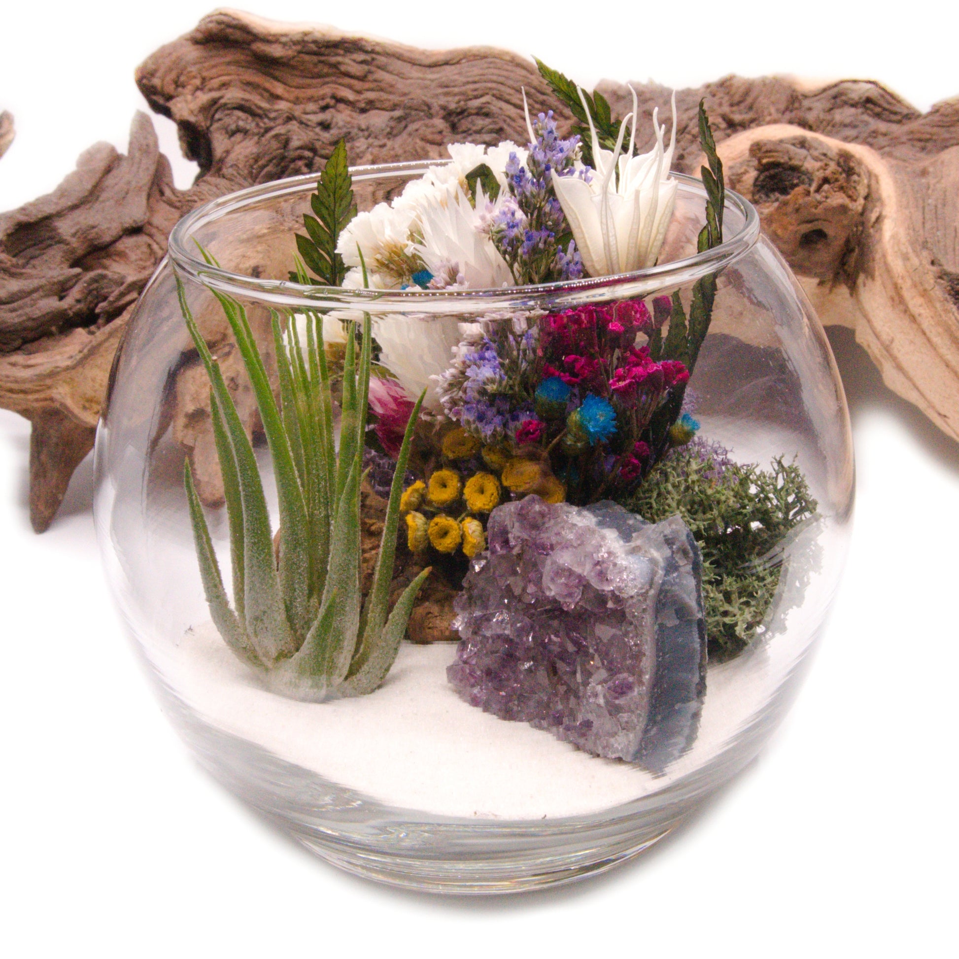 Airplant terrarium in a glass bowl with a bouquet of dried flowers, moss, wood and a raw amethyst crystal.