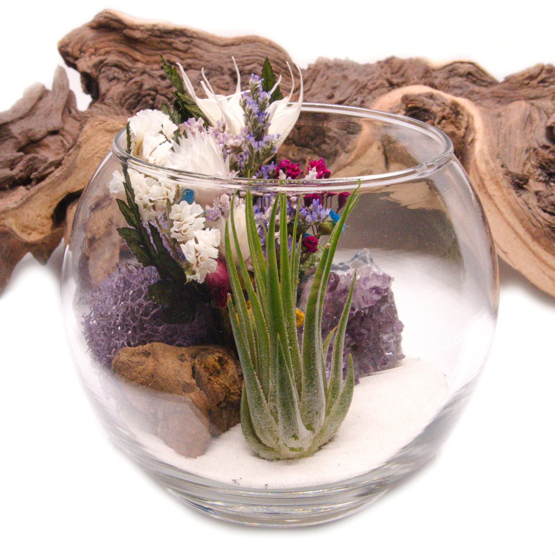 Airplant terrarium in a glass bowl with a bouquet of dried flowers, moss, wood and a raw amethyst crystal.